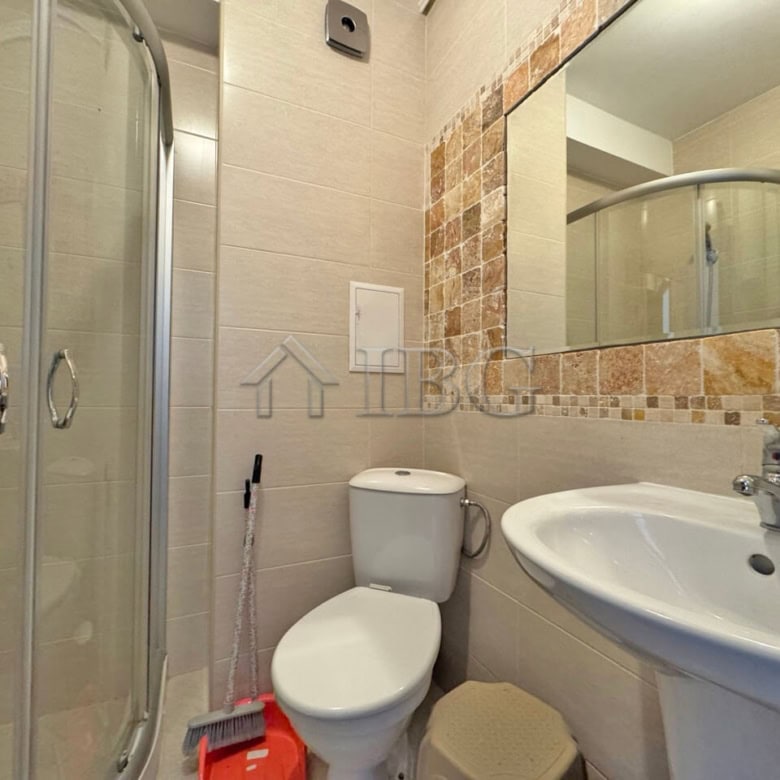 Modern bathroom with shower, toilet, and sink in Sunny Beach apartment.