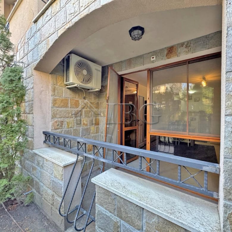 Bright 1-bedroom apartment balcony with glass doors and outdoor air conditioning unit.