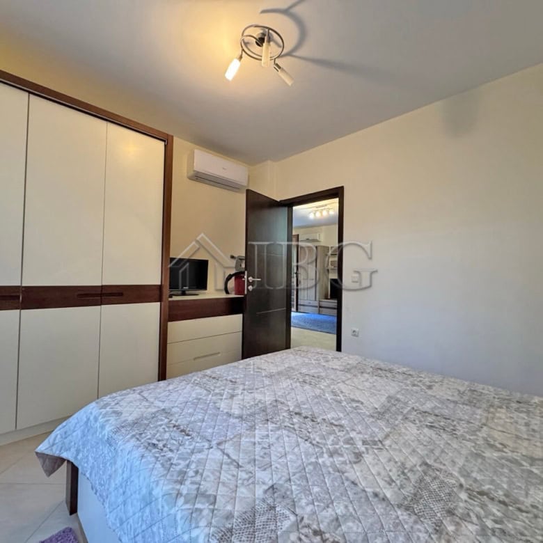 Apartment interior with bed, wardrobe, and door to balcony in Cascadas Family Resort, Sunny Beach.