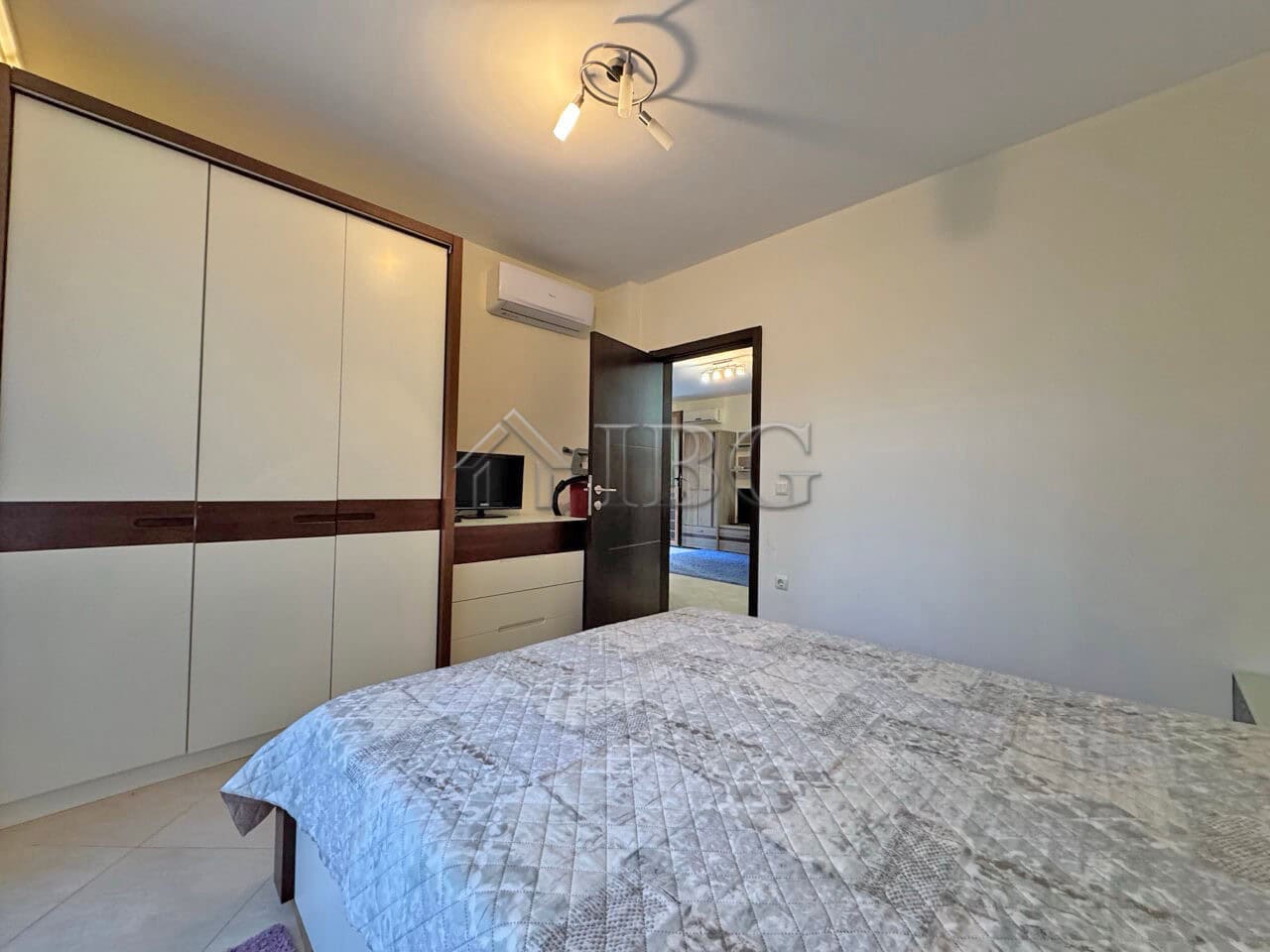 Apartment interior with bed, wardrobe, and door to balcony in Cascadas Family Resort, Sunny Beach.