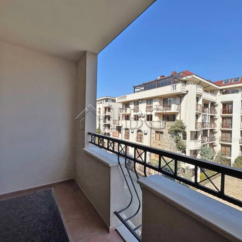 Balcony overlooking Sunny Beach apartments with clear blue sky and modern buildings.