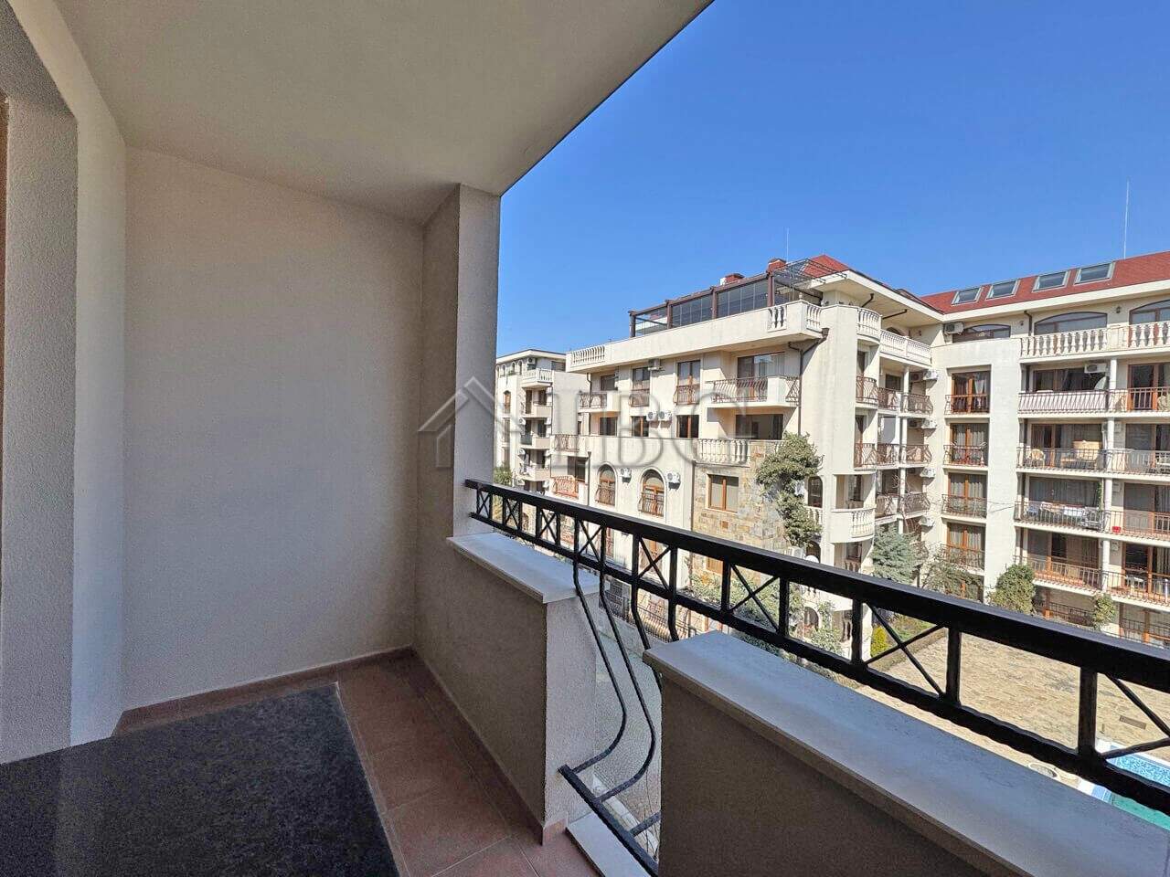 Balcony overlooking Sunny Beach apartments with clear blue sky and modern buildings.