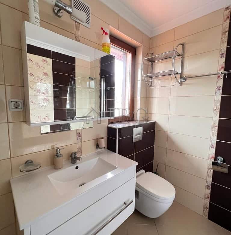 Modern bathroom with white sink and toilet in a bright apartment.