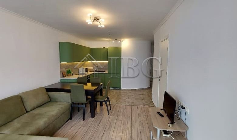 Bright living room with green kitchen cabinets and dining area in Sveti Vlas apartment.