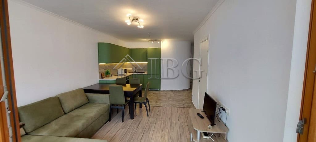 Bright living room with green kitchen cabinets and dining area in Sveti Vlas apartment.