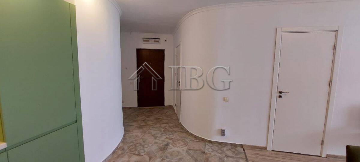 Bright interior view of a contemporary apartment entrance with white walls and wooden flooring.