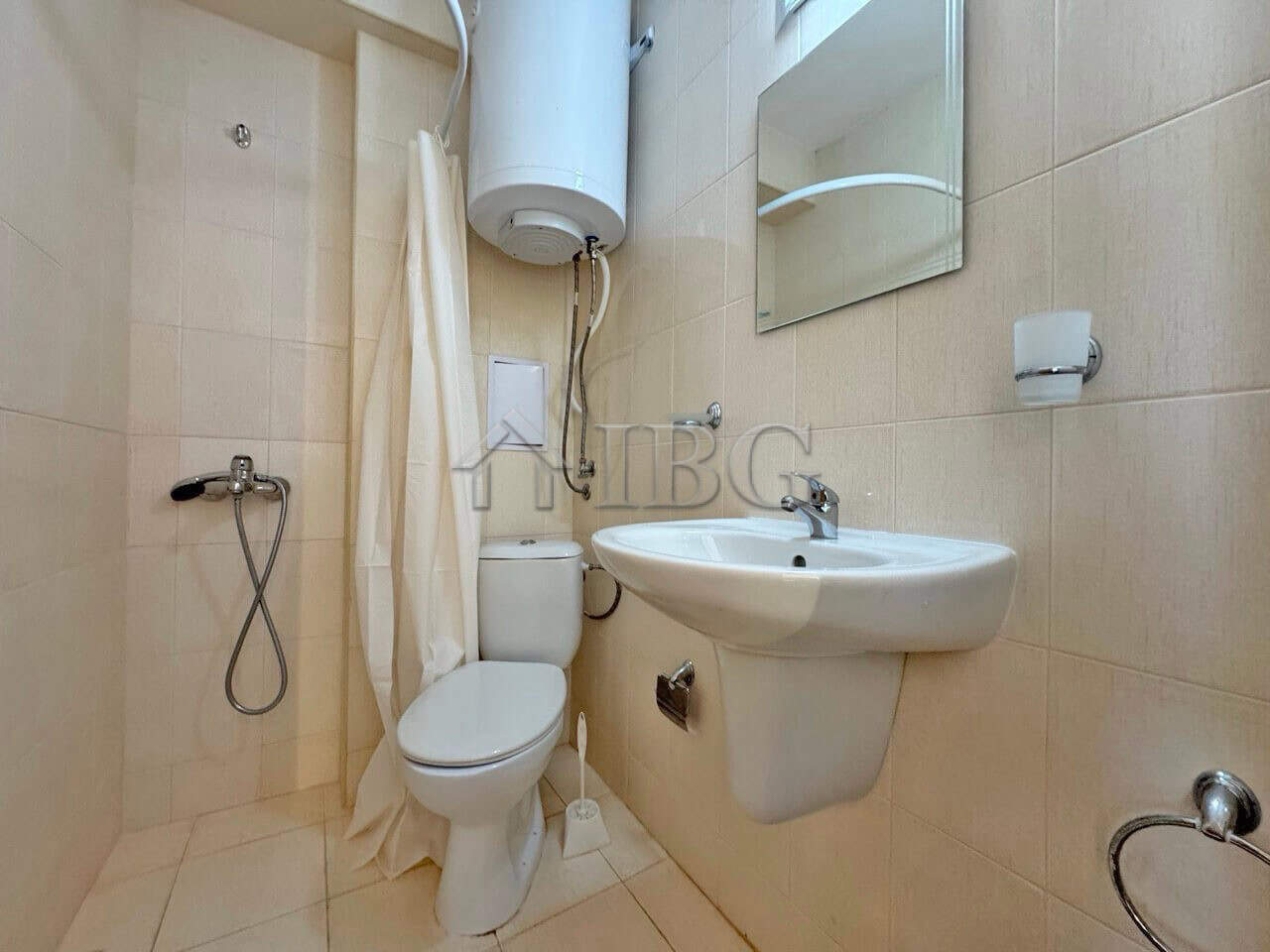 Compact bathroom with shower, toilet, and sink in Diamond Bay studio apartment, Sunny Beach.