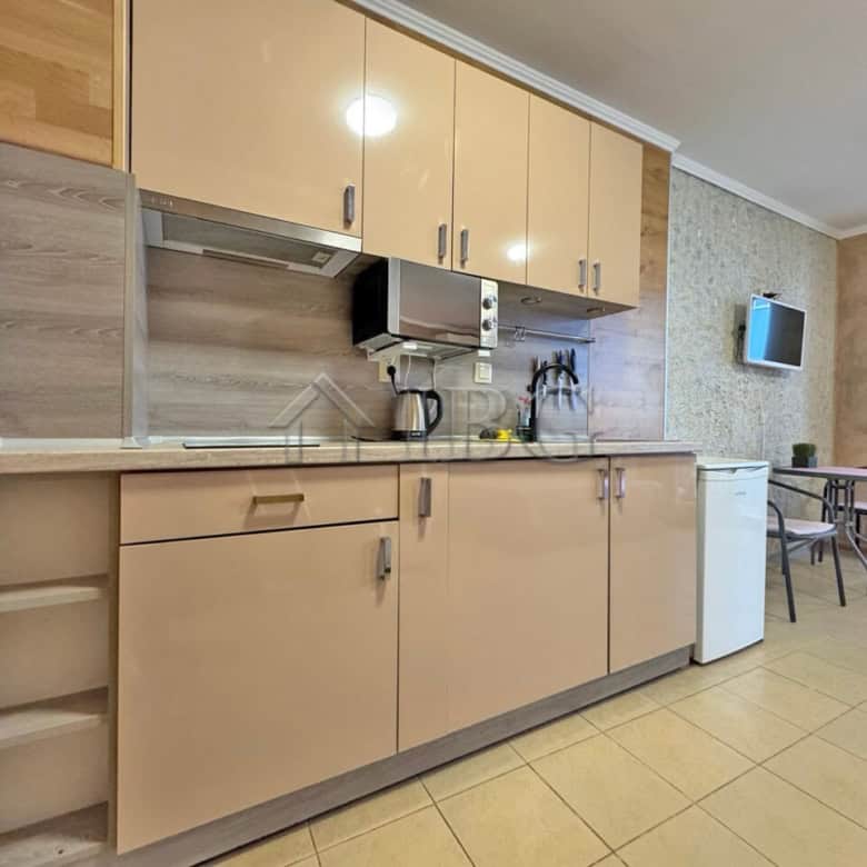 Cozy kitchen area in a studio apartment at Diamond Bay, Sunny Beach, Bulgaria. Modern cabinets, smal.