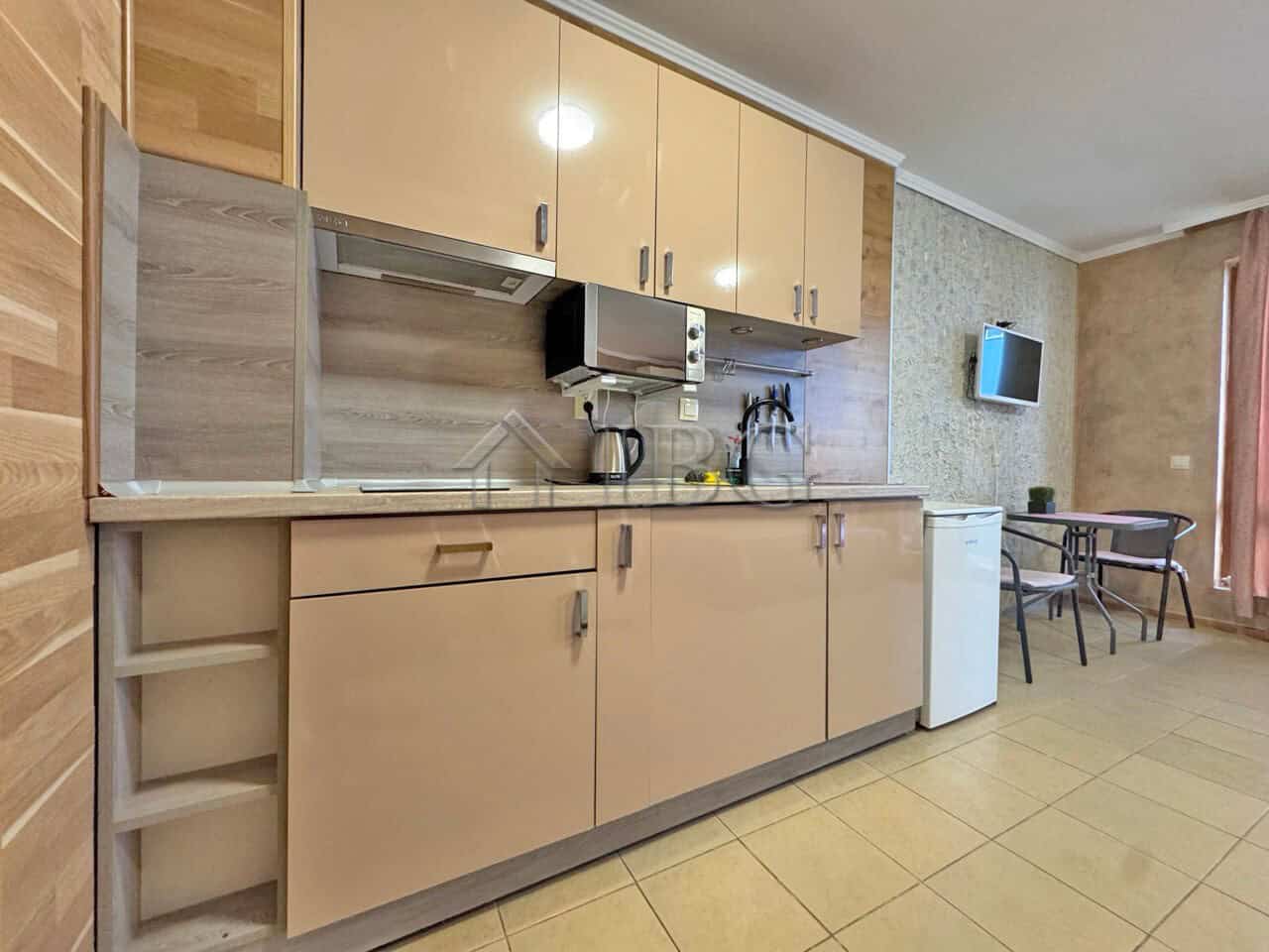 Cozy kitchen area in a studio apartment at Diamond Bay, Sunny Beach, Bulgaria. Modern cabinets, smal.