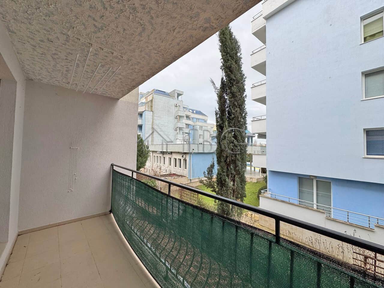 Balcony view of a studio apartment in Diamond Bay, Sunny Beach, with modern buildings and greenery.