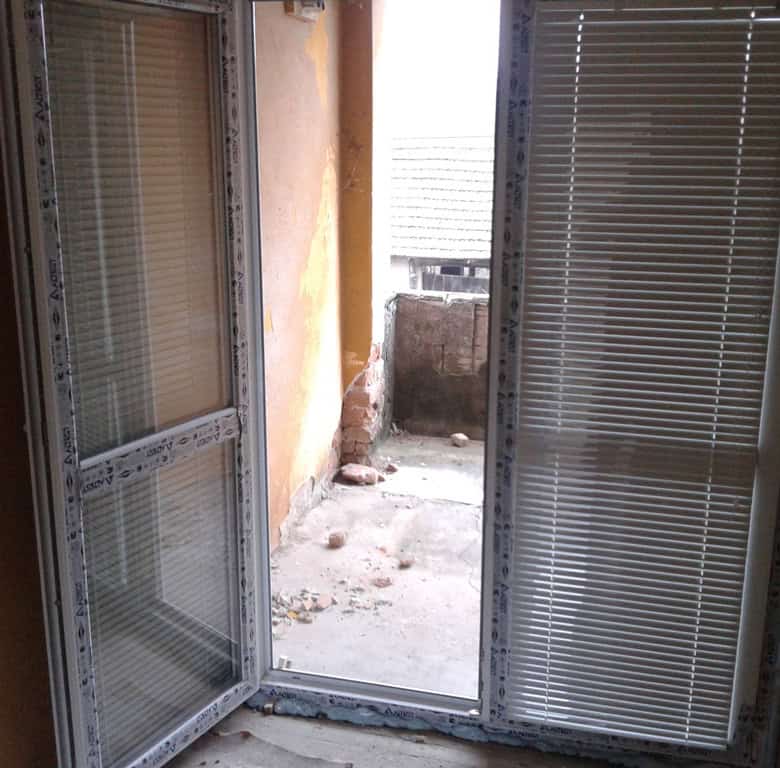 Interior view of a house under renovation in Bulgaria, showing unfinished walls and open balcony doo.
