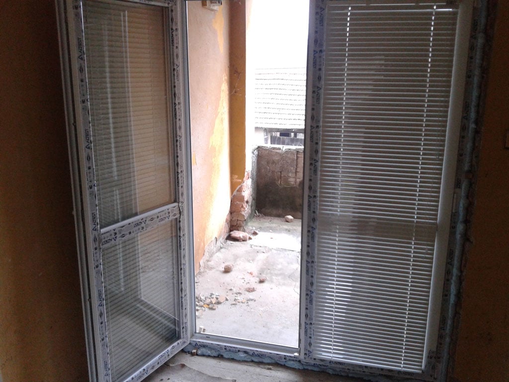 Interior view of a house under renovation in Bulgaria, showing unfinished walls and open balcony doo.