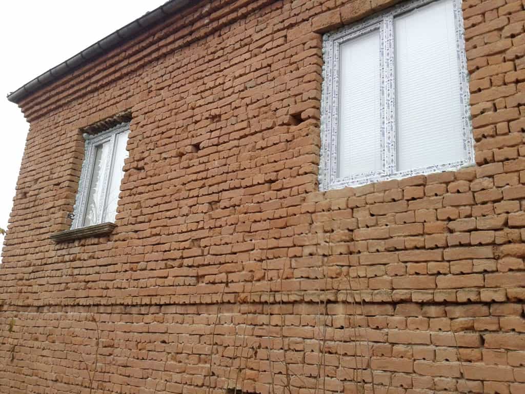 Exterior view of a brick house for renovation in Stezherovo, Bulgaria.