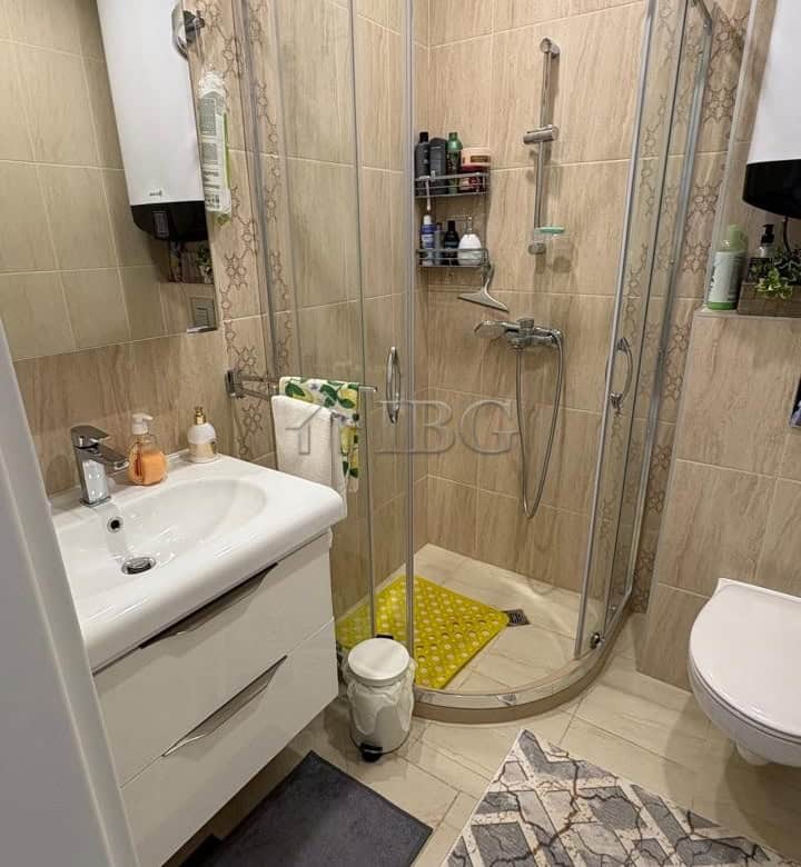 Comfortable 1-bedroom apartment with modern shower, located in Pomorie Residence, offering a relaxin.