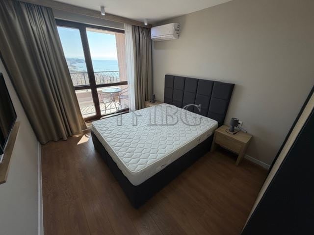 Sea view bedroom in luxury apartment with balcony and modern furnishings.