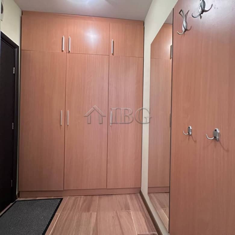 Interior view of a 1-bedroom apartment in Ravda with wooden wardrobes and hallway hooks.