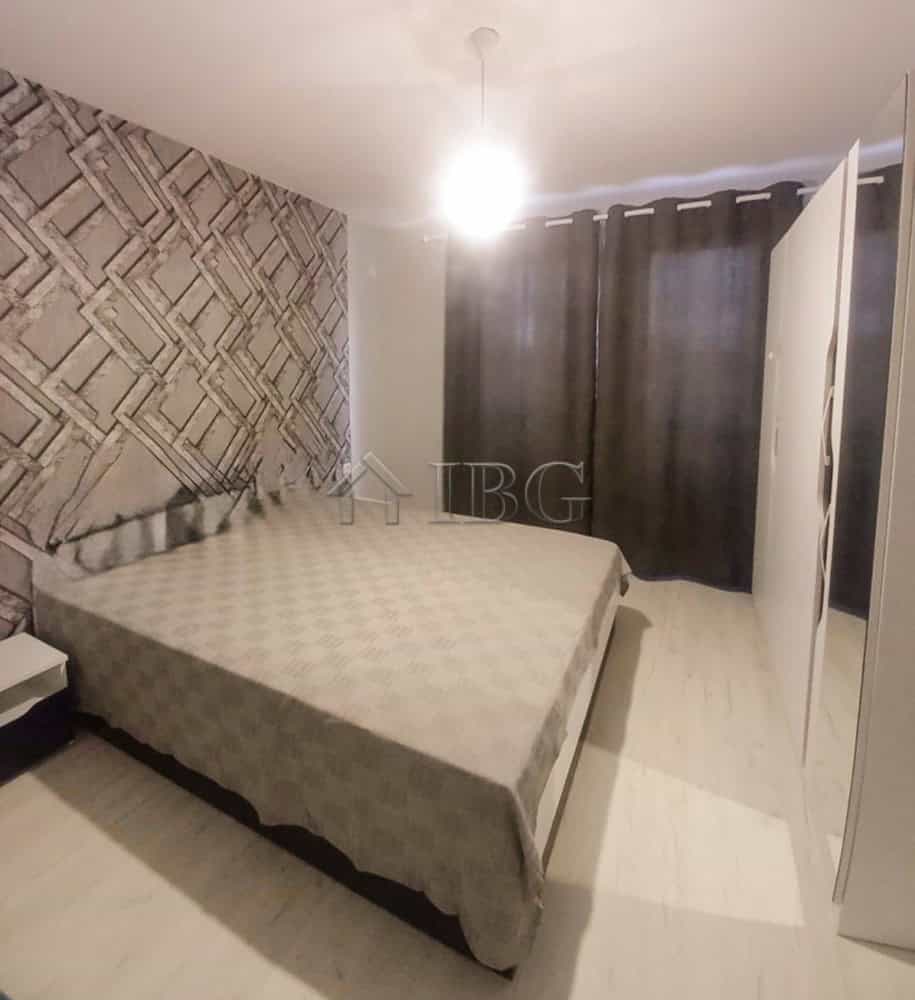 Furnished bedroom with a double bed, modern decor, and dark curtains in a central Ruse apartment.