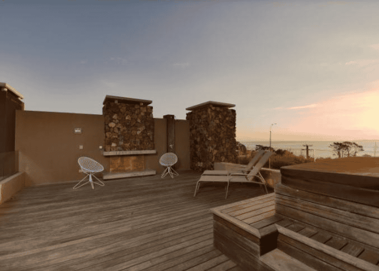 Rooftop terrace with ocean views, outdoor seating, and sunset in P. Ballena Maldonado.