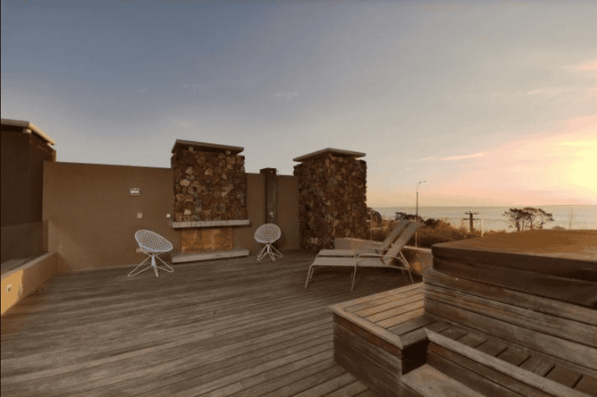 Rooftop terrace with ocean views, outdoor seating, and sunset in P. Ballena Maldonado.