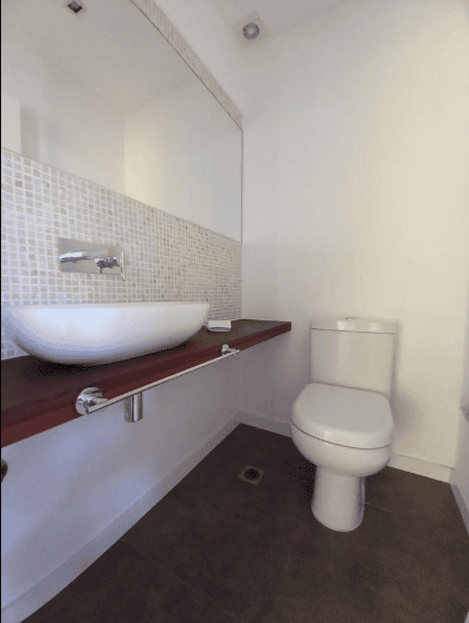 Contemporary bathroom with white toilet and vessel sink in P. Ballena Maldonado apartment.