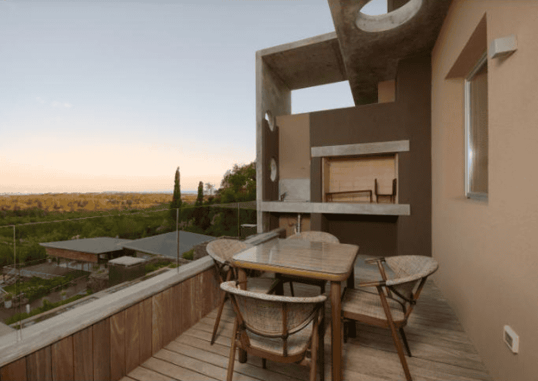 Balcony of a stylish apartment in P. Ballena Maldonado with outdoor dining furniture and scenic view.