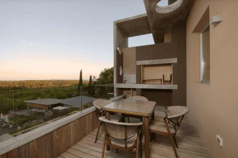 Balcony of a stylish apartment in P. Ballena Maldonado with outdoor dining furniture and scenic view.