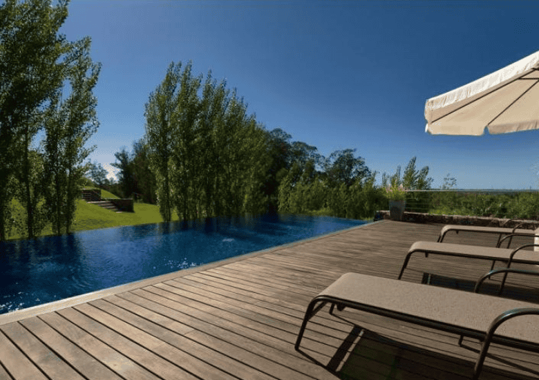 Poolside view of a luxurious apartment in P. Ballena Maldonado with outdoor lounging area.