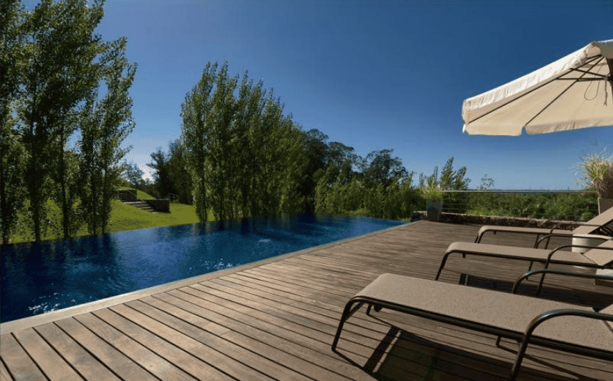 Poolside view of a luxurious apartment in P. Ballena Maldonado with outdoor lounging area.