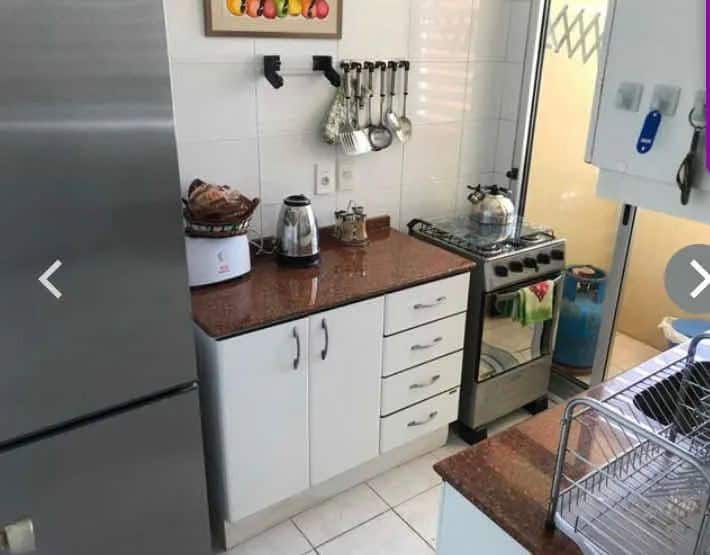 Compact kitchen with white cabinets, stove, and utensils in La Pastora, Punta del Este, Maldonado.