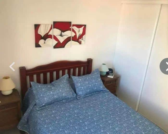 Comfortable bedroom with blue bedding and wooden furniture in La Pastora, Punta del Este.