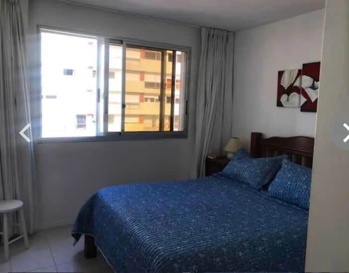 Bright bedroom with large window and sea view.