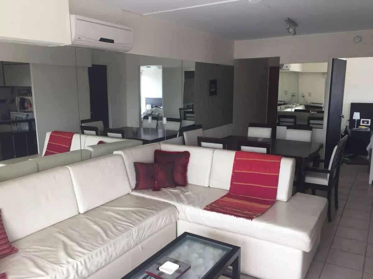 Spacious interior with white sofa, red cushions, and contemporary decor.