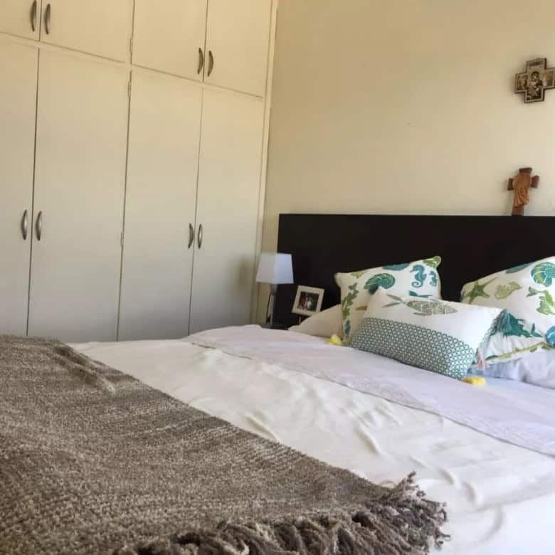 Spacious bedroom featuring a large bed, decorative pillows, and wall art in a coastal apartment.