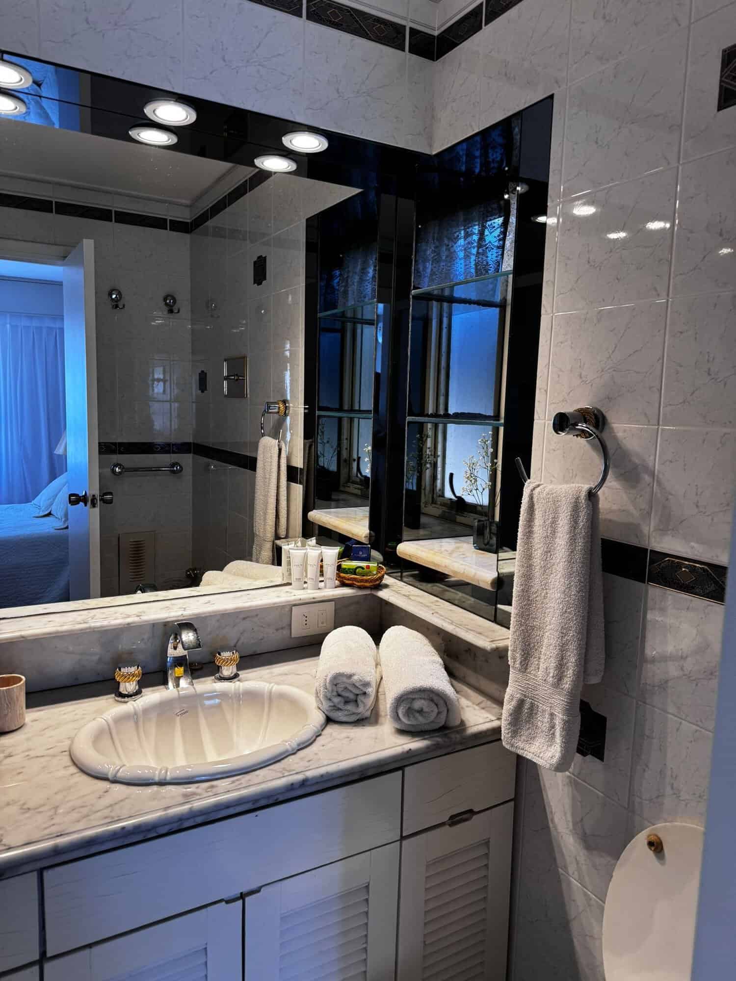 Bathroom with marble vanity, towels, and large mirror in Punta del Este.