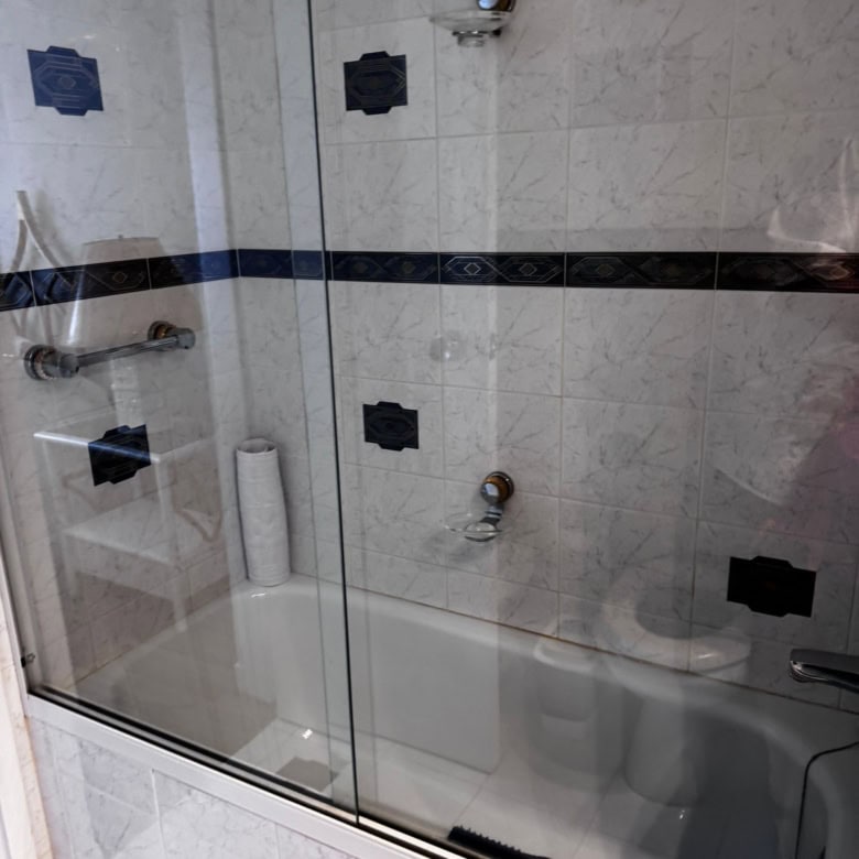 Bathroom with bathtub, glass shower enclosure, and modern tile design.