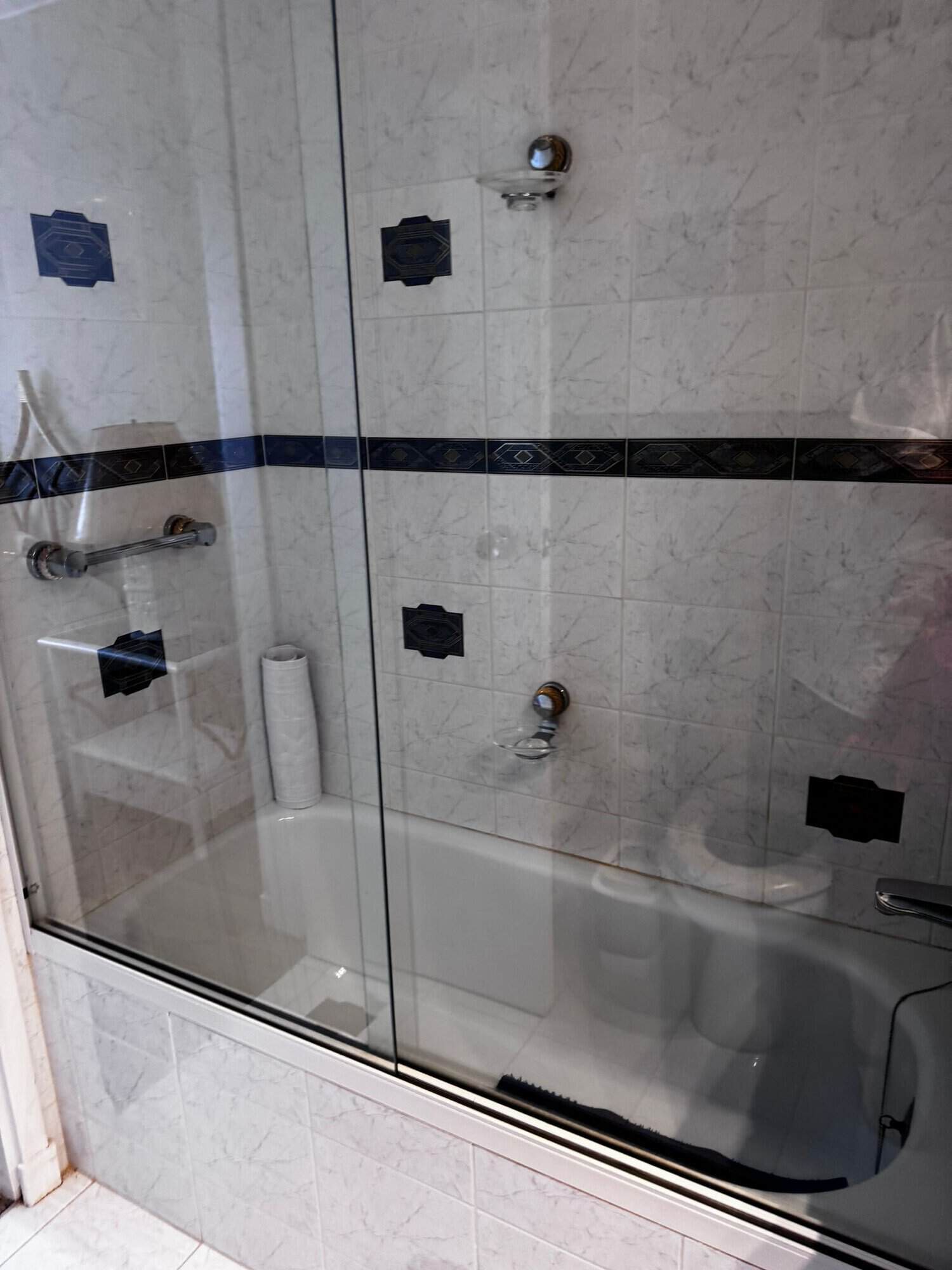 Bathroom with bathtub, glass shower enclosure, and modern tile design.