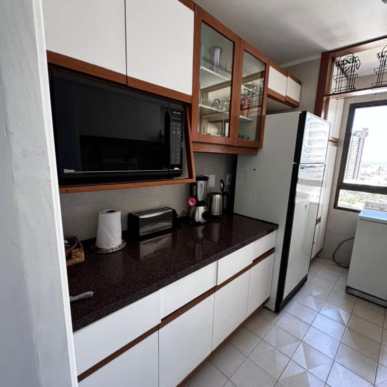 Kitchen with microwave, refrigerator, and storage in Punta del Este property.