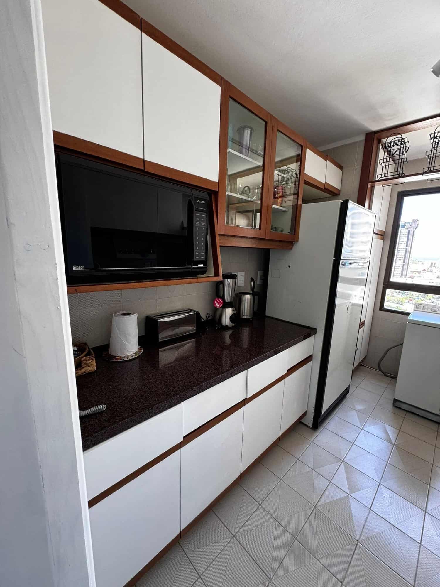 Kitchen with microwave, refrigerator, and storage in Punta del Este property.