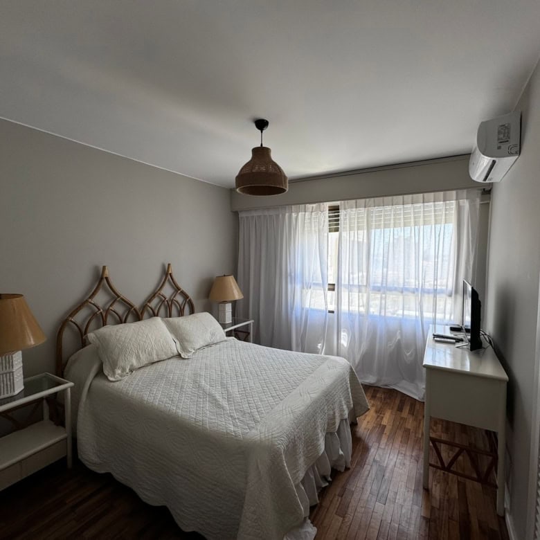 Bright bedroom with large window and modern decor in Punta del Este property.
