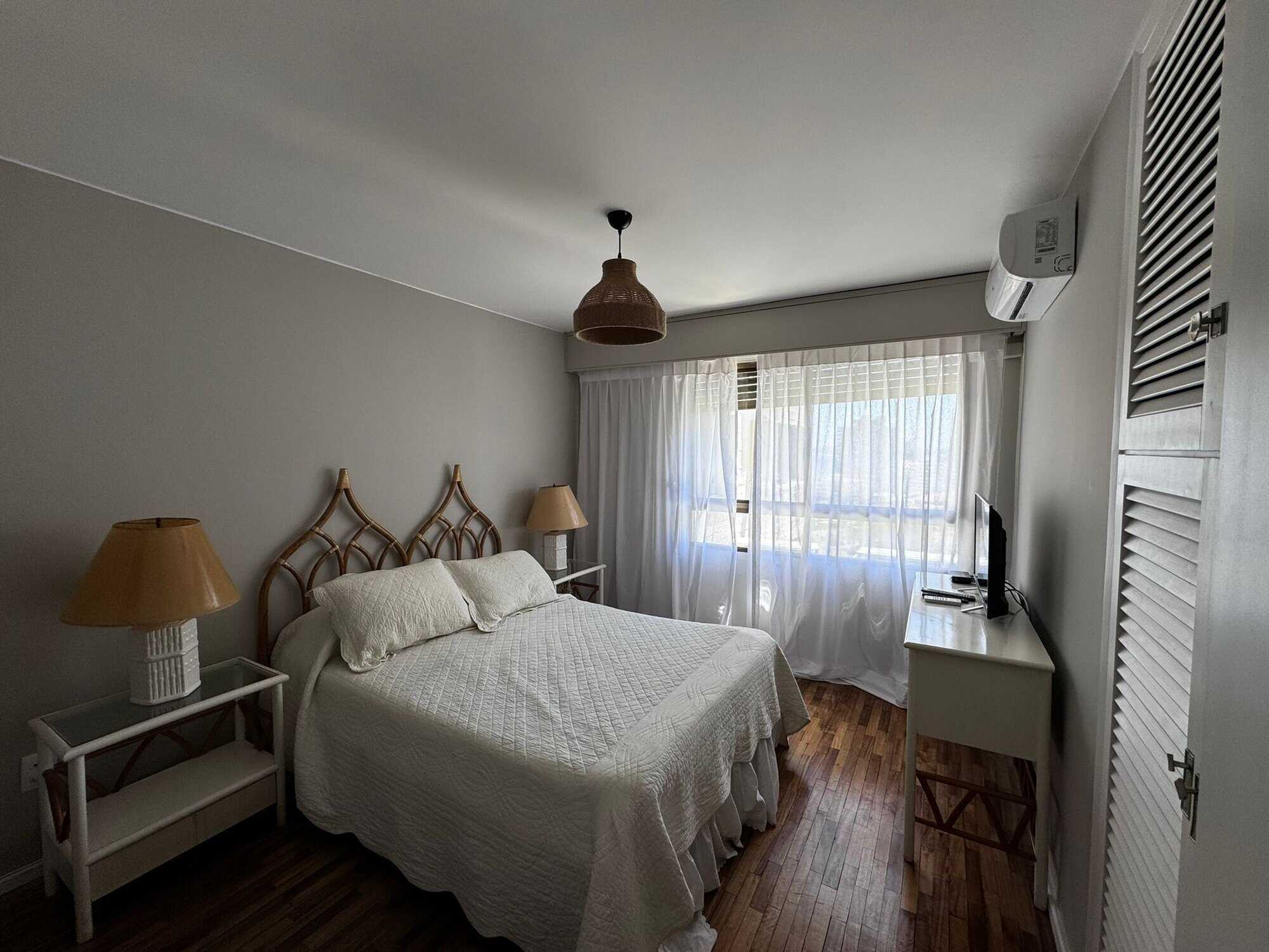Bright bedroom with large window and modern decor in Punta del Este property.
