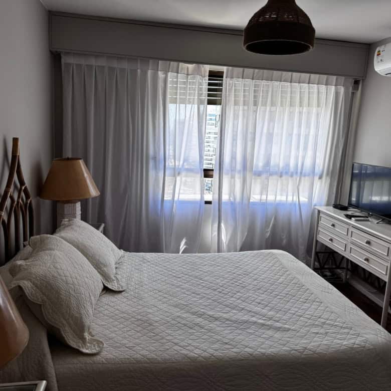 Bright bedroom with large window and air conditioning.