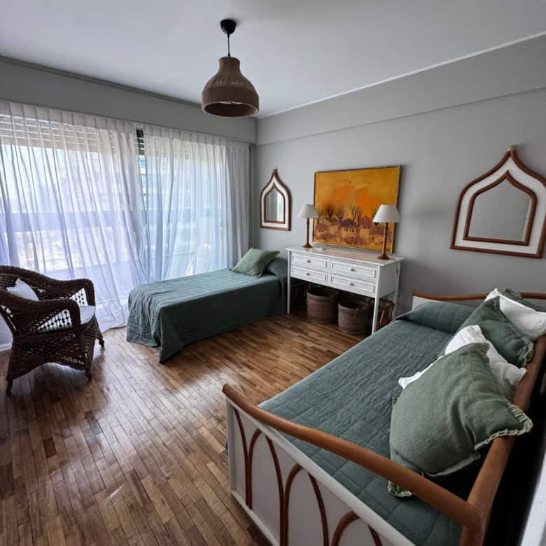 Bright living room in Punta del Este apartment with two beds and natural light.