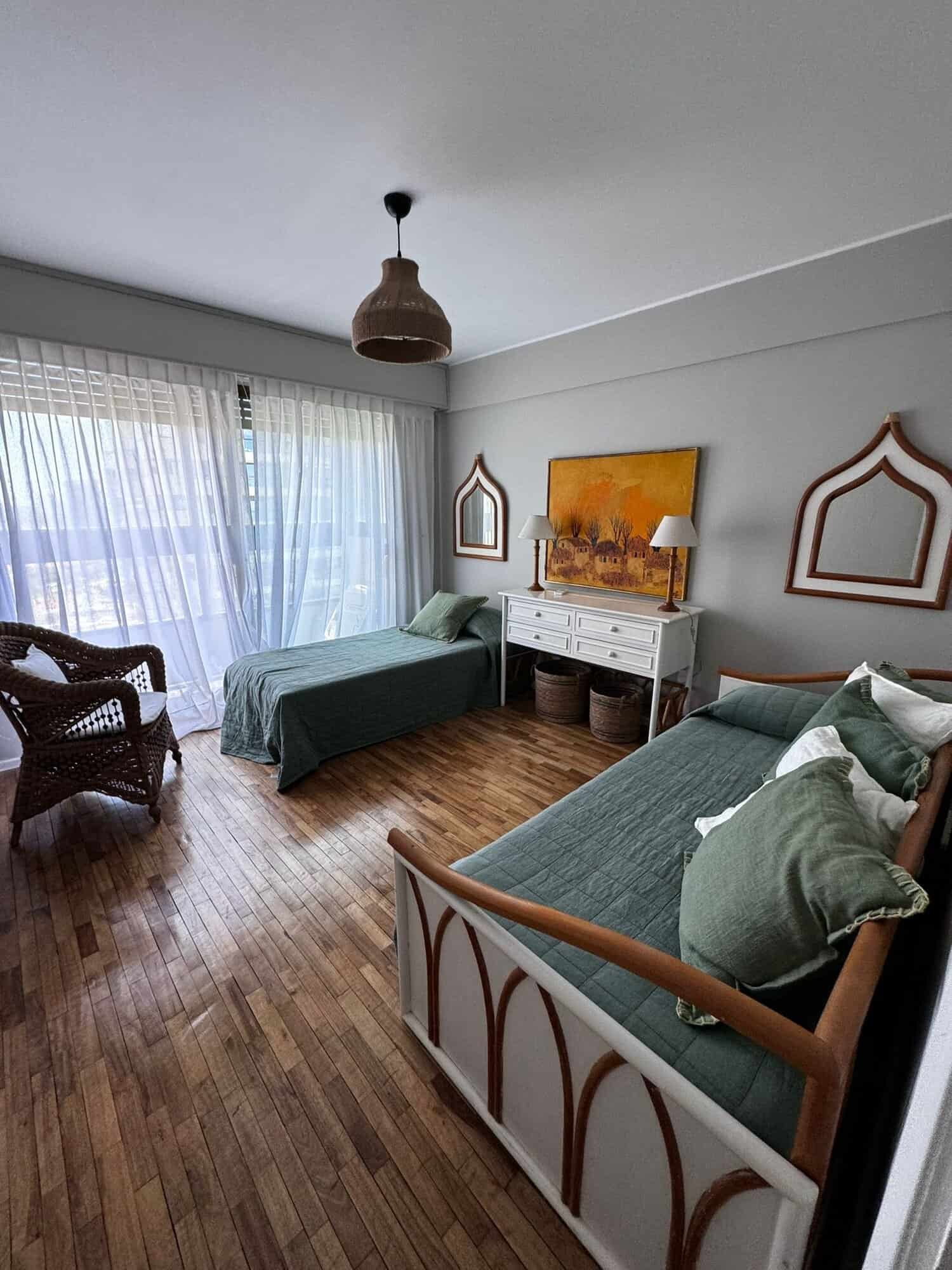Bright living room in Punta del Este apartment with two beds and natural light.