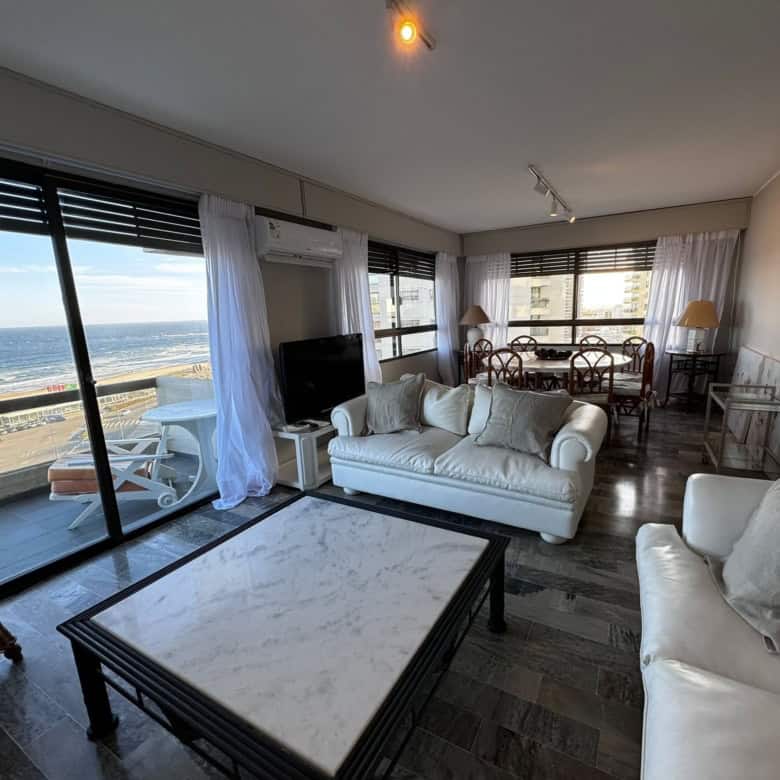 Spacious living room with large windows overlooking the ocean in Punta del Este, Maldonado. Modern f.