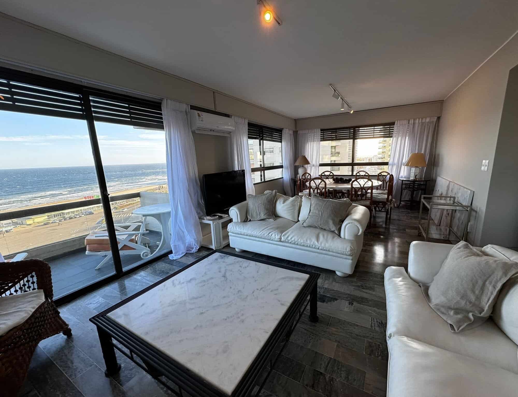 Spacious living room with large windows overlooking the ocean in Punta del Este, Maldonado. Modern f.