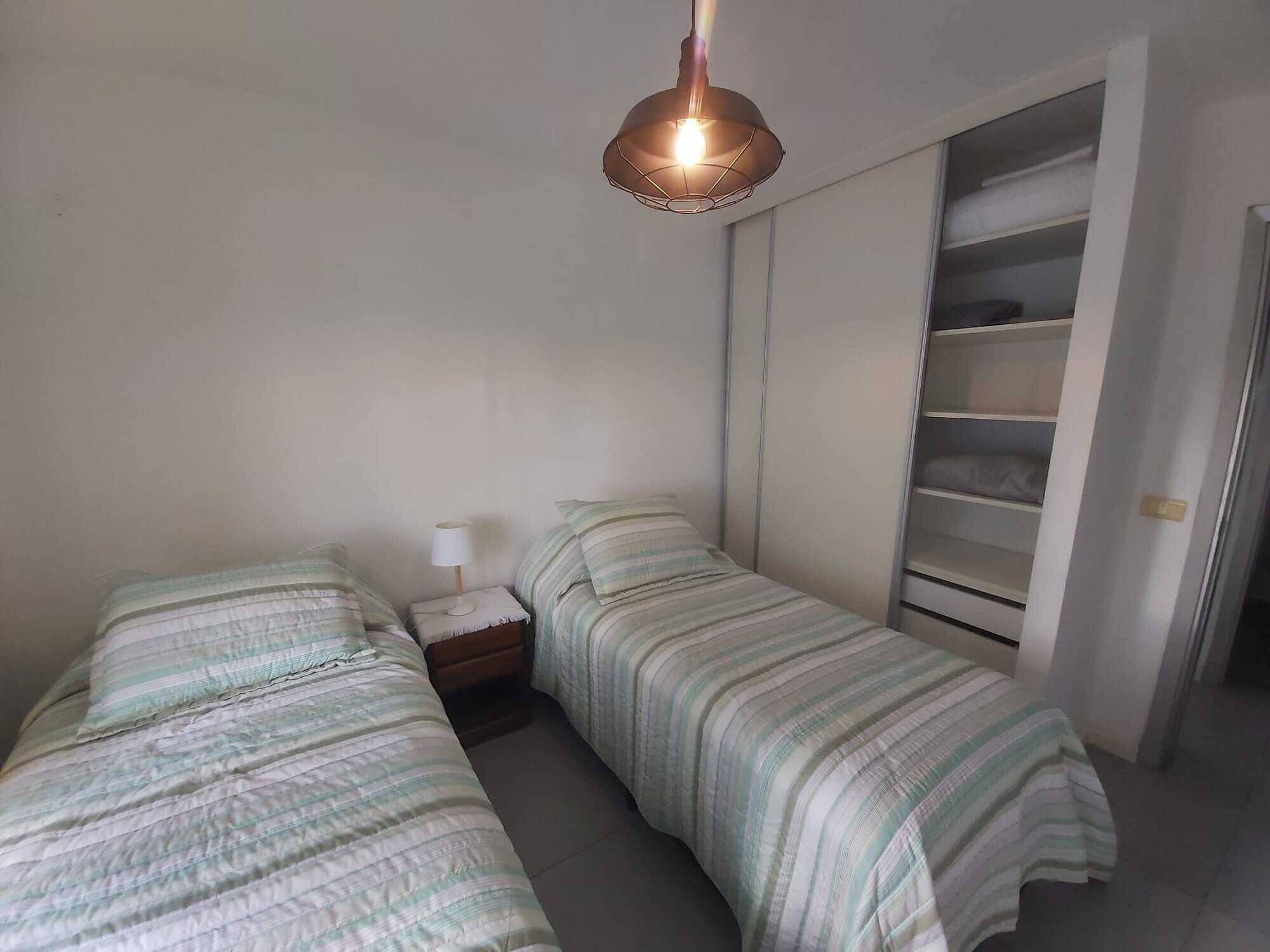 Bright bedroom with two single beds and built-in closet in Punta del Este.