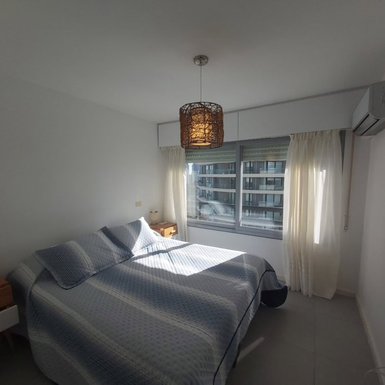 Spacious bedroom featuring a large window with natural light in Punta del Este property.