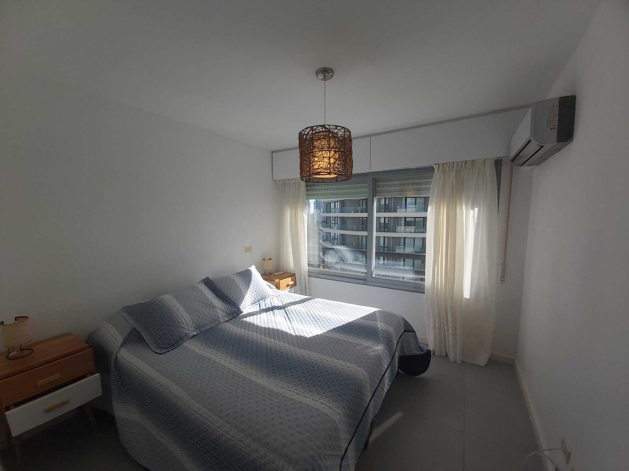 Spacious bedroom featuring a large window with natural light in Punta del Este property.