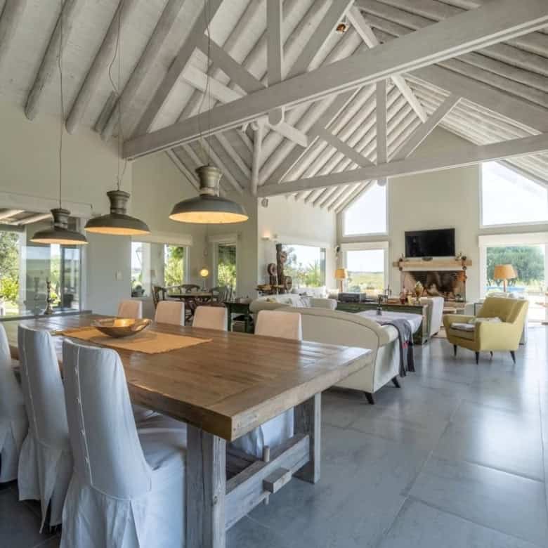 Spacious open-plan living and dining area with high vaulted ceilings and large windows in Punta Ball.