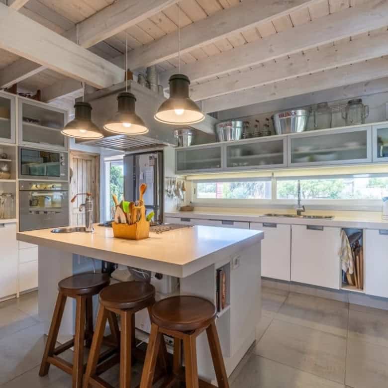 Spacious kitchen featuring white cabinets, a central island, and ample natural light.